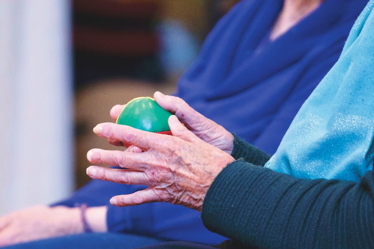 Older woman squeezing a soft exercise ball to keep her finger joints mobile