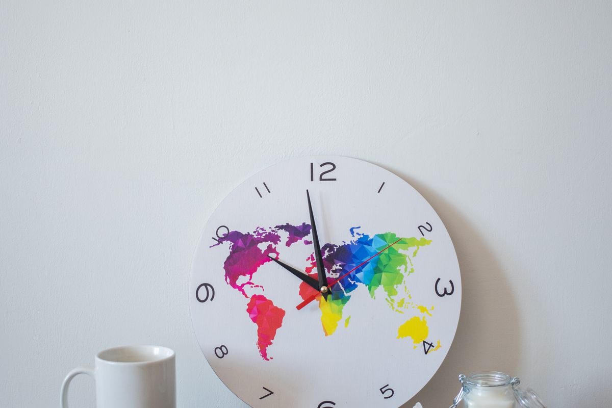 Wall clock with a world map, representing consultations across time zones